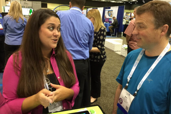 Professional woman consulting with a dentist at a conference.