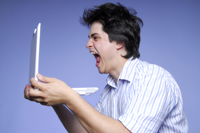 an angry, emotional man yelling into his computer