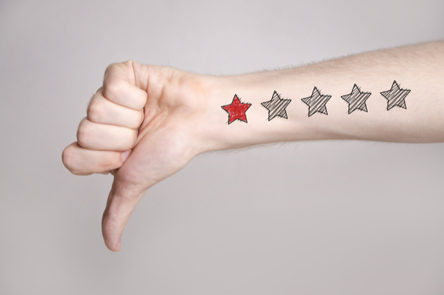 an arm pointing a thumb down, with one star scrawled in red on it