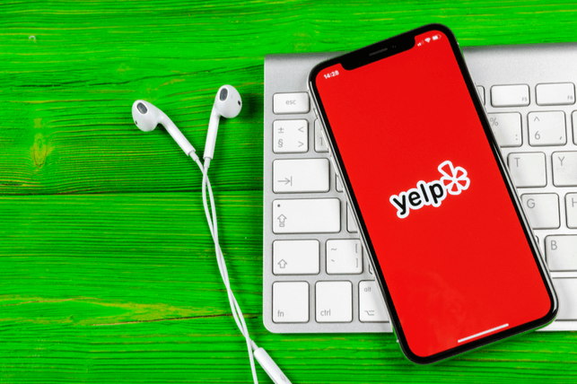 Phone with Yelp app open lying on keyboard